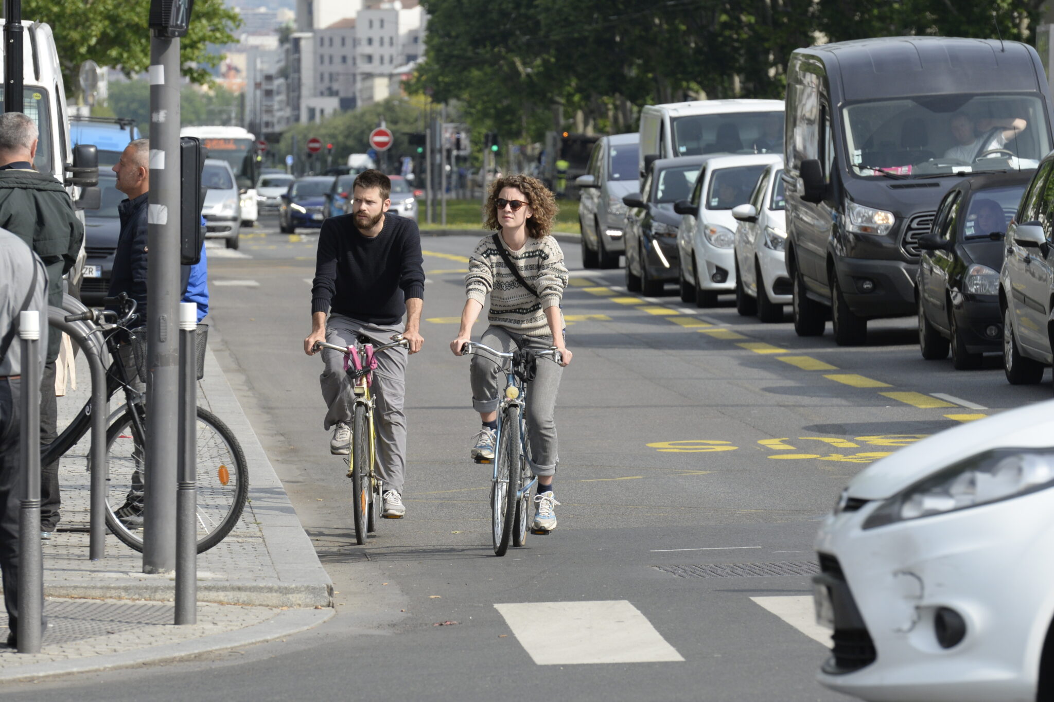 Deux cyclistes cotes à cotes sur une voie partagé bus/vélo